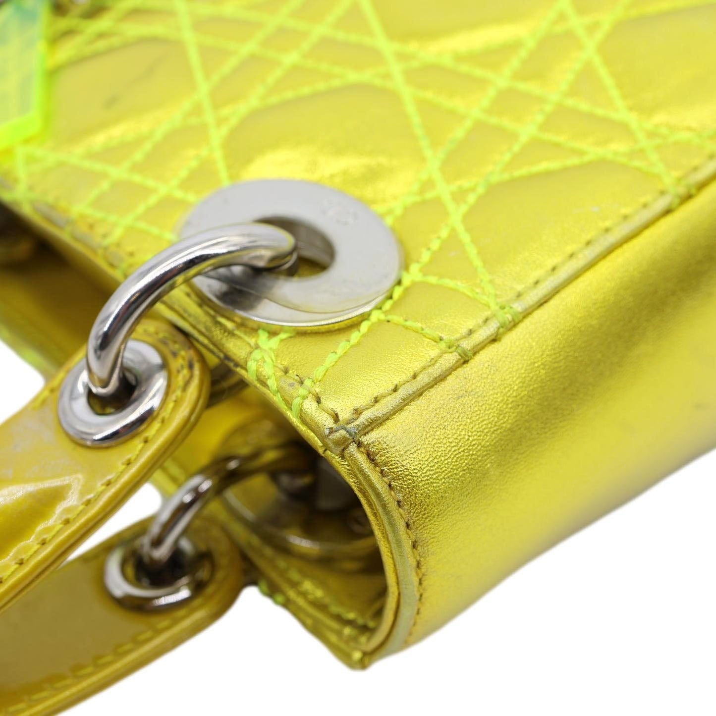 Close-up of CHRISTIAN DIOR Lady Dior Mini Metallic Leather Shoulder Bag Neon Yellow with signature Cannage stitching and charms.
