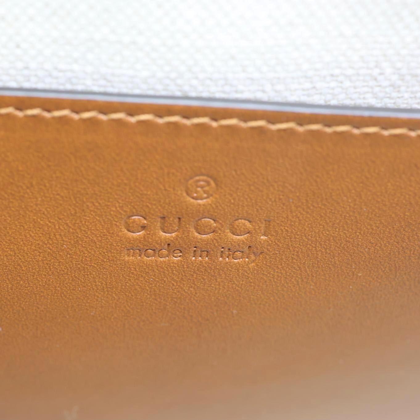 GUCCI Logo Small Embossed Calfskin Leather Shoulder Bag Brown 679540 close-up view of embossed leather detail with logo.