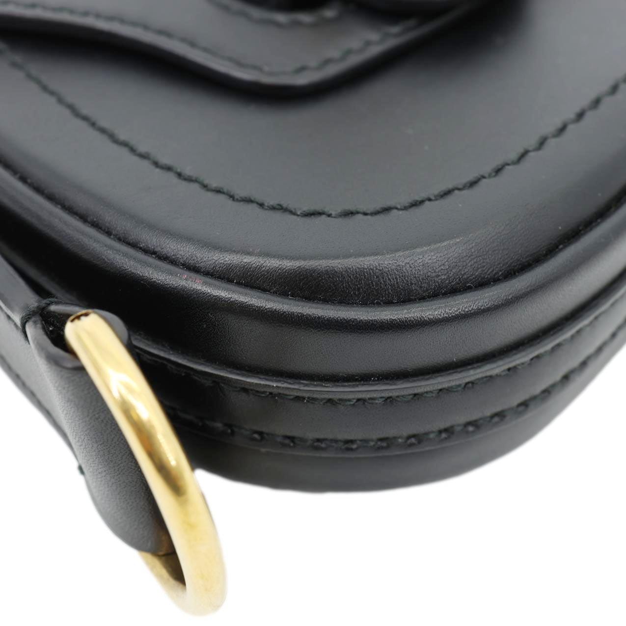 Close-up of CHRISTIAN DIOR D Fence Small Calfskin Leather Saddle Bag Black showcasing smooth leather and gold-tone details.