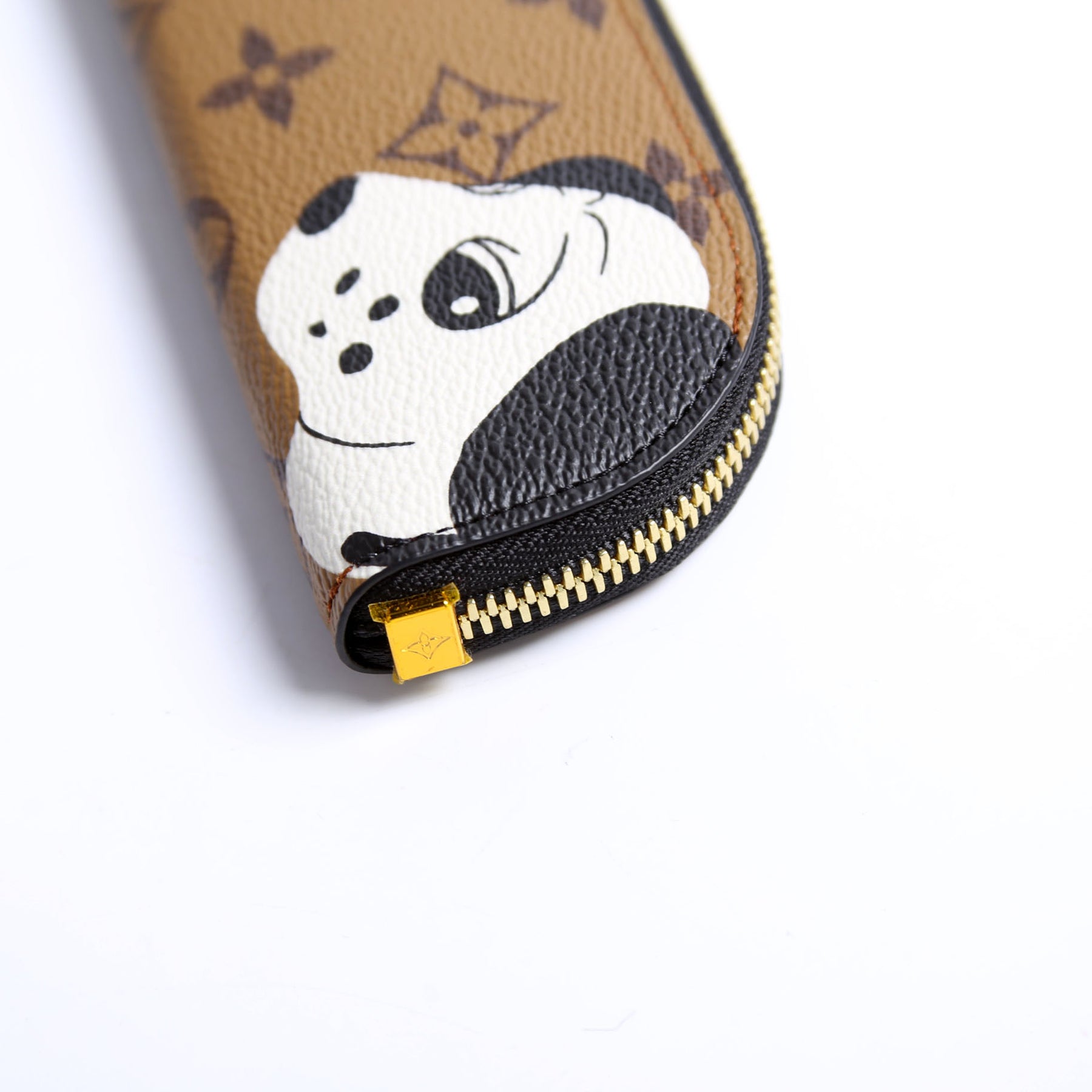 Close-up of Louis Vuitton Come and Play With Me Charlotte Pencil Pouch Reverse Monogram with unicorn zipper, brown graphic design.